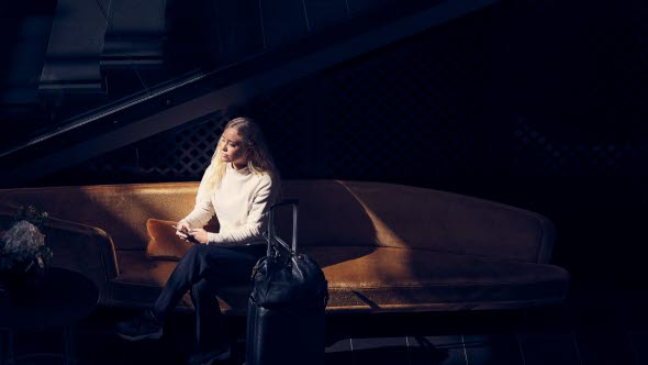 Woman sitting on a couch with a briefcase